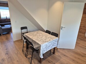 Ein Essbereich mit einem Tisch, vier Stühlen und einer Tür.