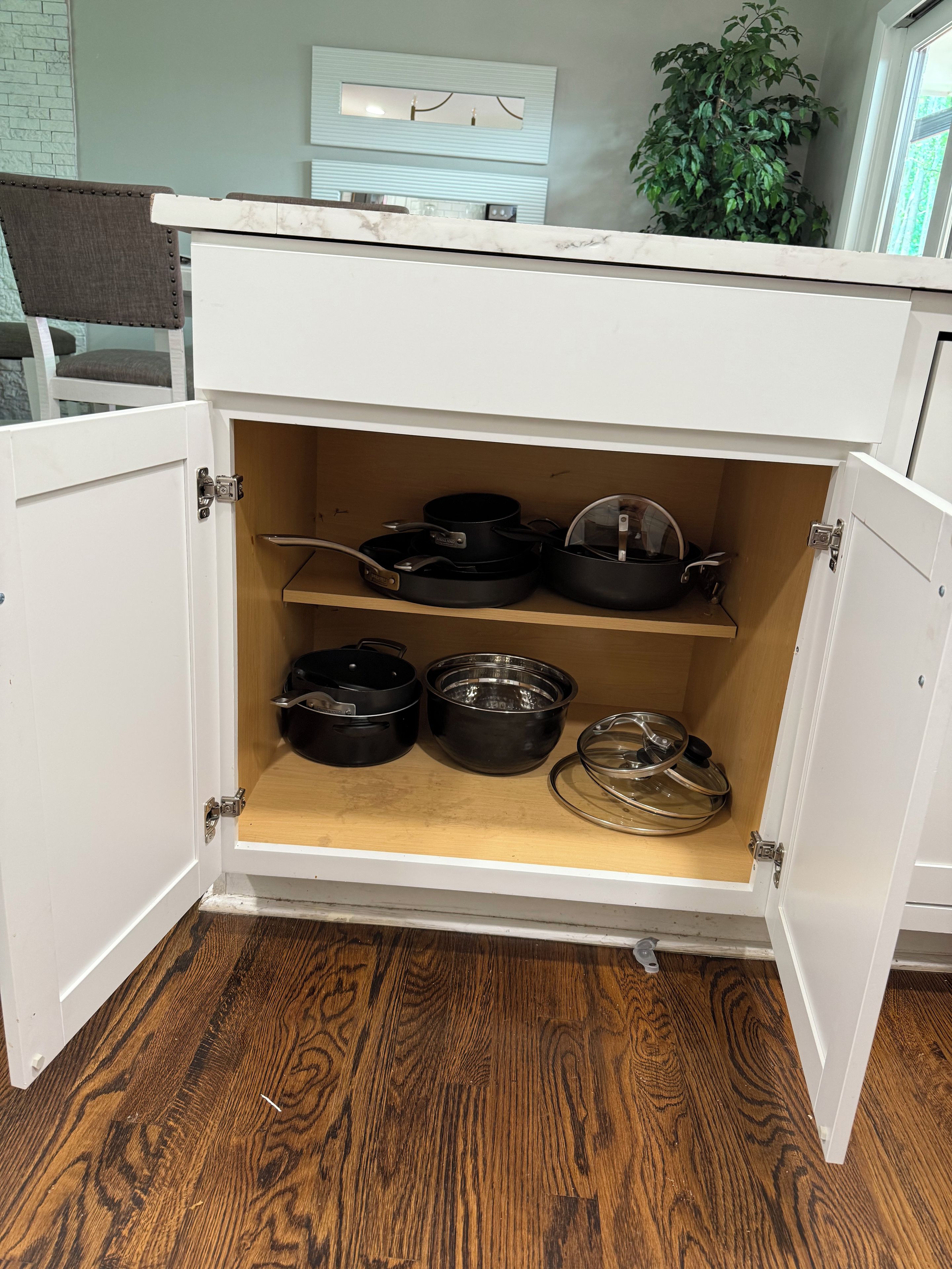 Un meuble de cuisine doté de trois étagères, chacune servant à ranger les ustensiles de cuisine.