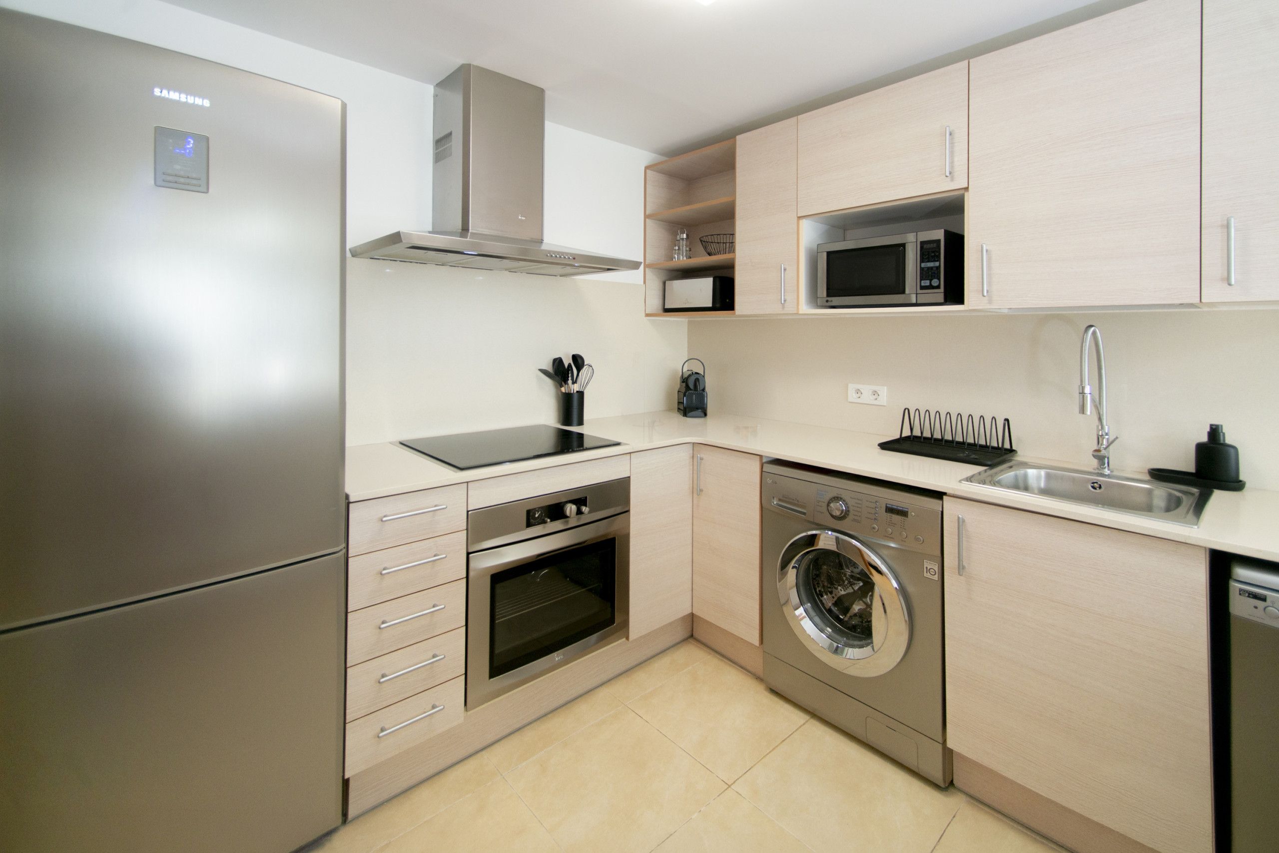 A compact kitchen with a built-in oven, microwave, and dishwasher.