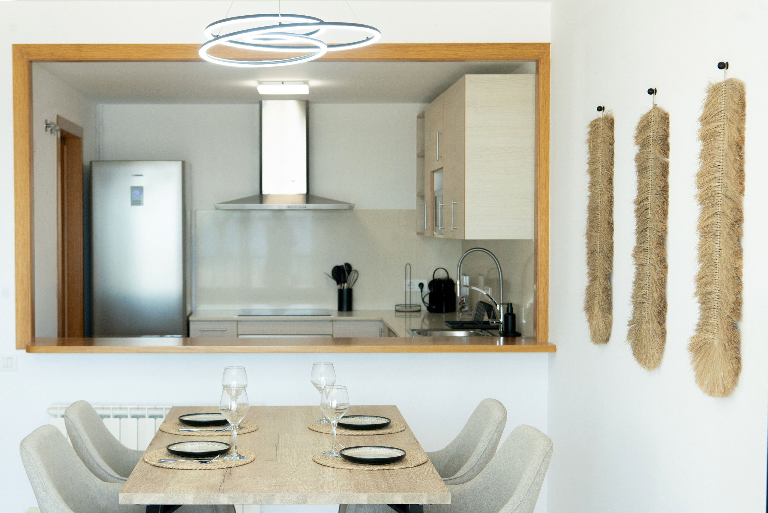 Une cuisine moderne dotée d’un four encastré, d’une hotte en acier inoxydable et d’un plan de travail en bois.