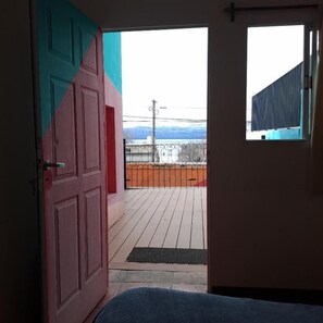 Quarto com vista para uma varanda, uma porta e uma janela.