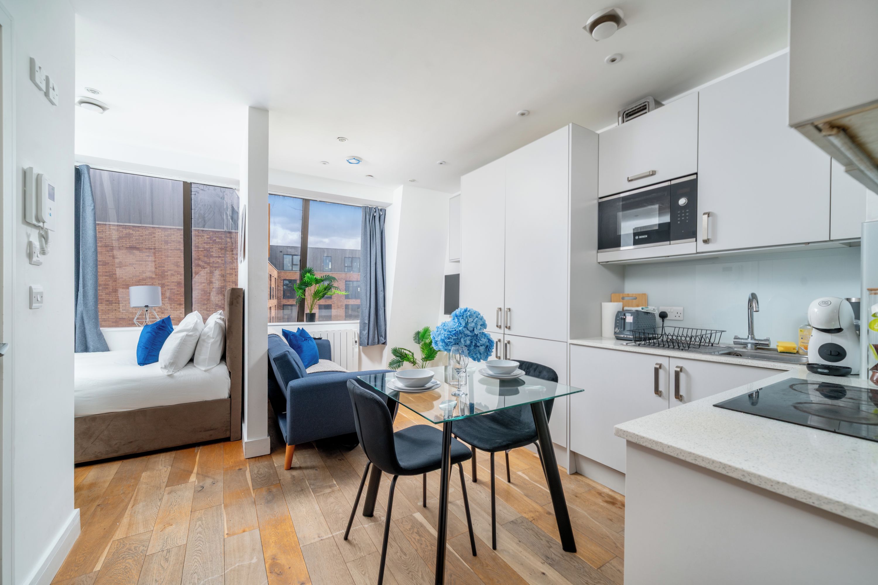 Un appartement moderne doté d’un coin repas, d’une kitchenette et offrant une vue sur la ville.