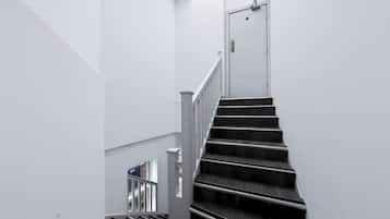 A staircase with a white door at the top, leading to an upper floor.