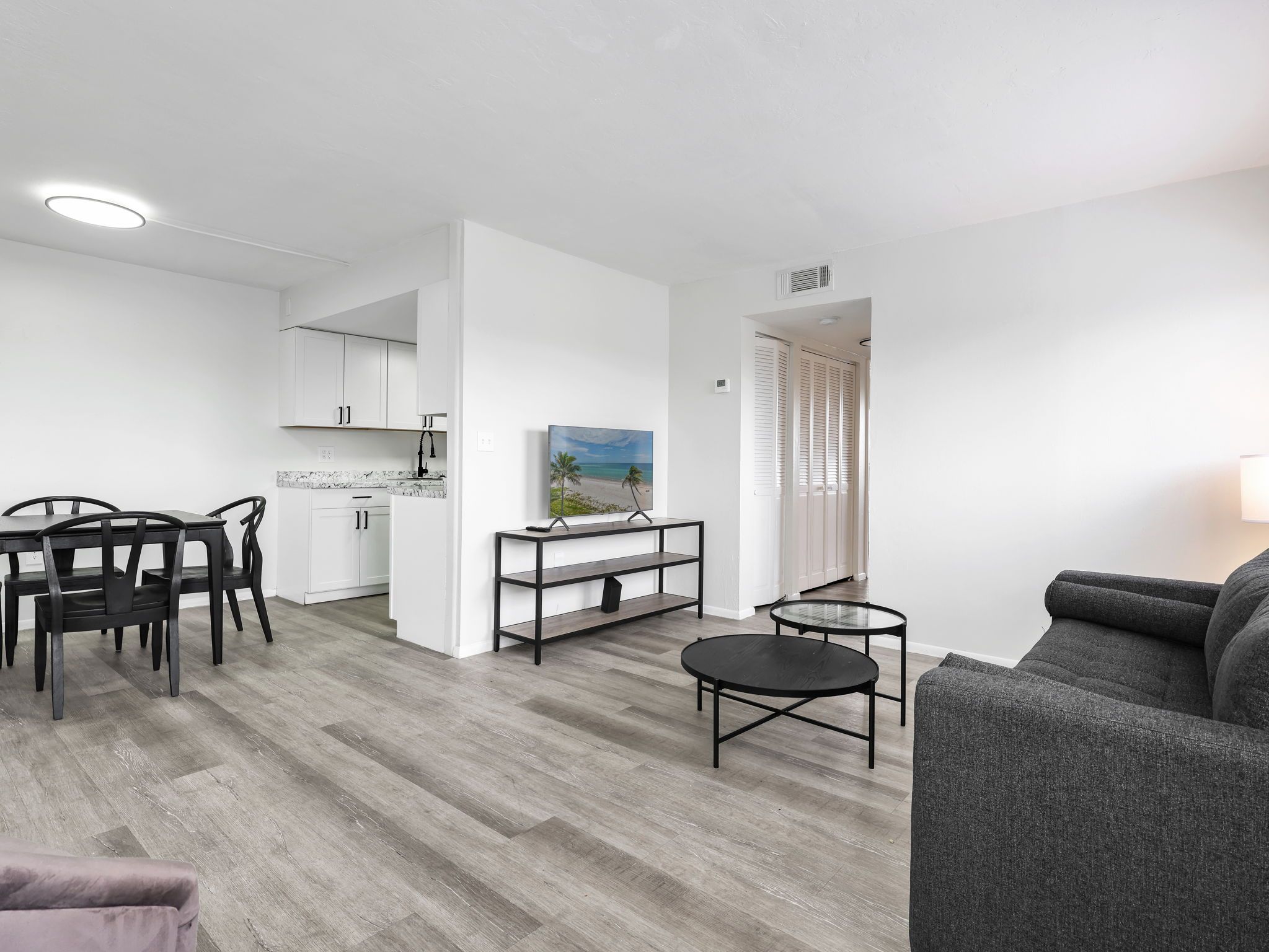 En moderne lejlighed med spiseplads, køkken og opholdsstue.