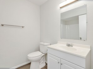 Une salle de bain avec des toilettes, un lavabo et un miroir.