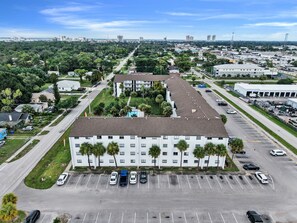 Un immeuble à plusieurs étages avec un parking situé à l’avant.