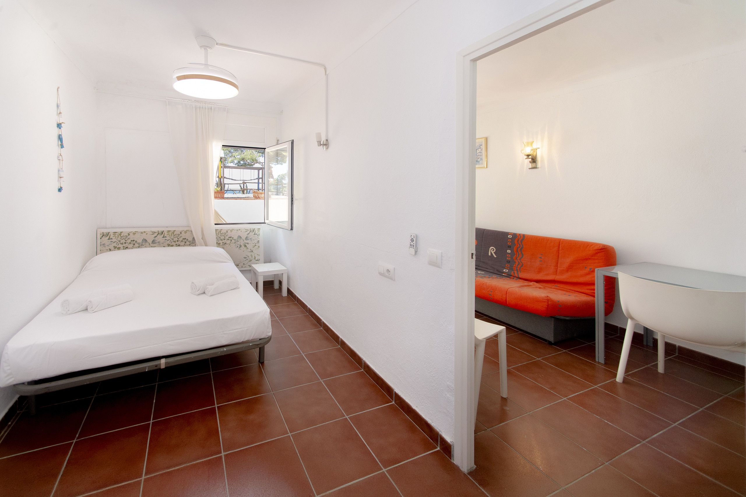 A compact room with a bed, a small table, and a sofa.