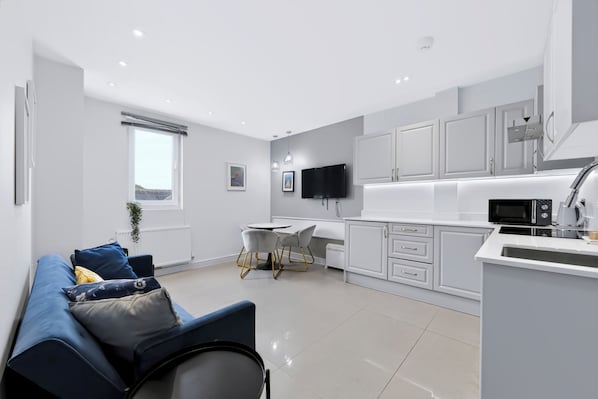 Un appartement moderne comprenant un espace de vie, une cuisine et un coin repas.