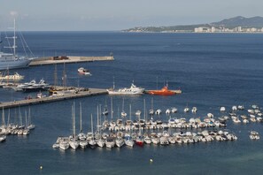 Un port de plaisance où sont amarrés différents types de bateaux, dont un grand yacht et un canot de sauvetage.