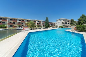 Ein Swimmingpool mit glatter, blauer Wasseroberfläche, umgeben von einer Betonplattform.