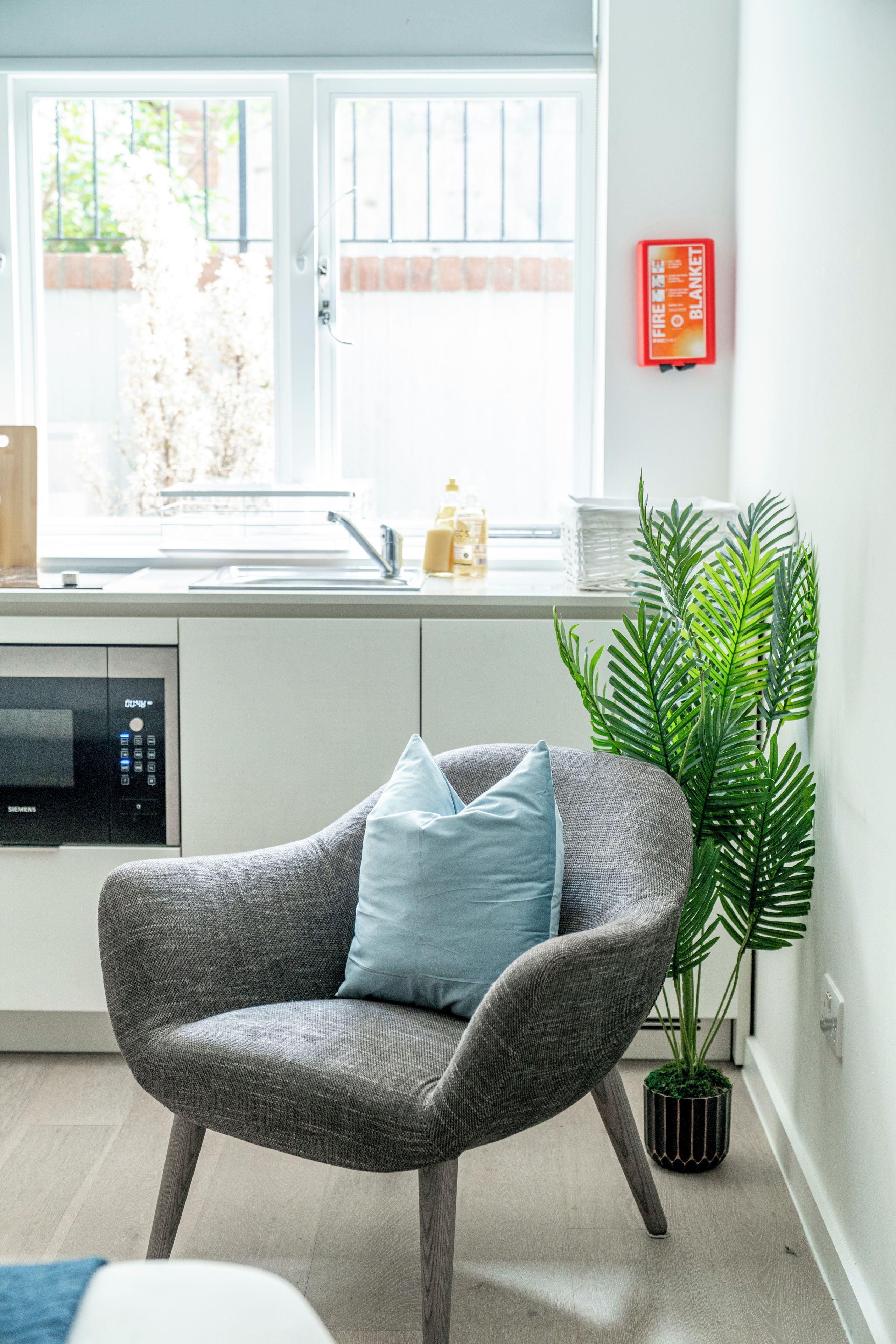 A modern kitchen with a built-in dishwasher, a sink, and a window with a view of the outside.