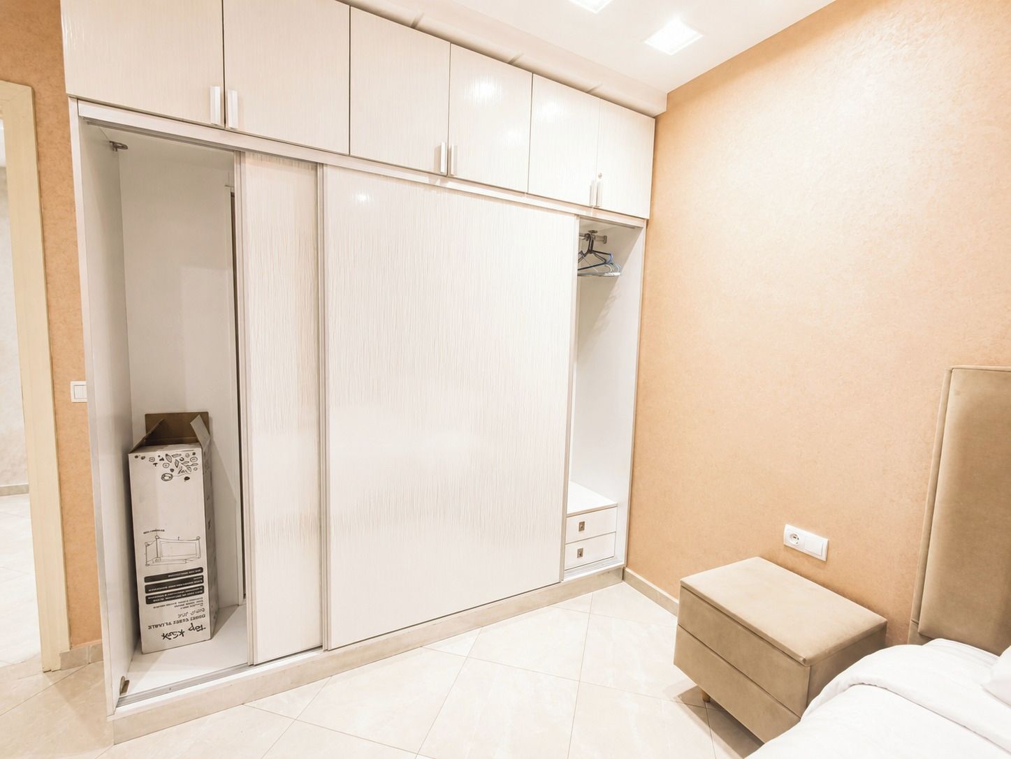 Une chambre à coucher comprenant un lit, une table de chevet, une armoire et un miroir.
