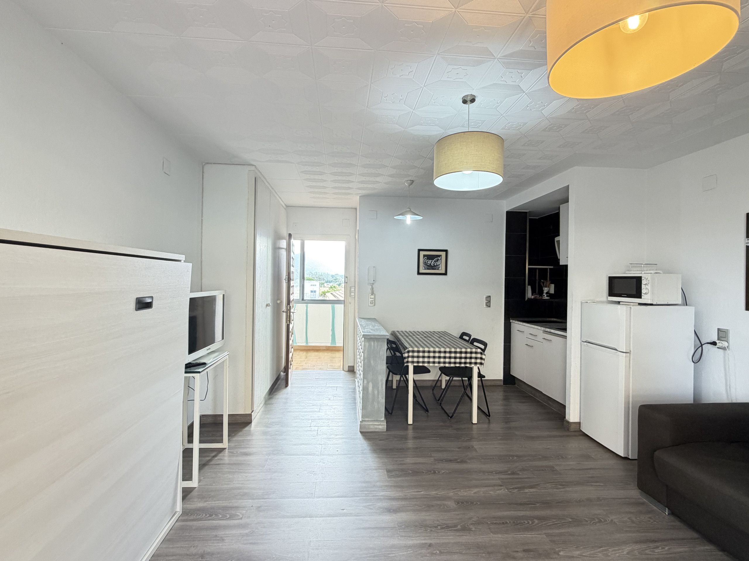 A modern kitchen with a dining area, a microwave, and a refrigerator.