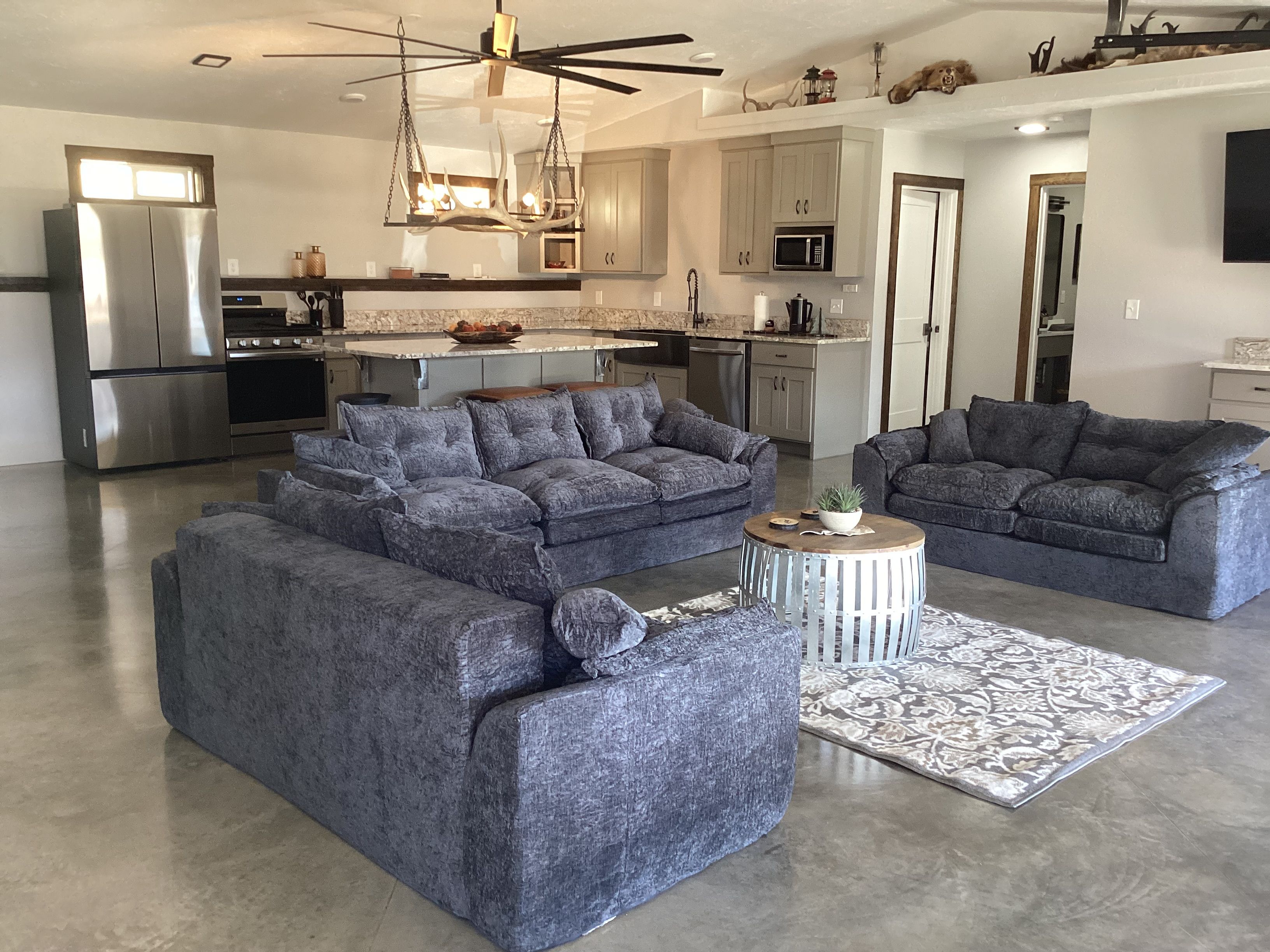 A modern living room with grey sofas, a coffee table, and a patterned rug.