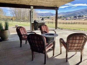 Un patio exterior con mobiliario de mimbre, una chimenea y un letrero que dice 'Friends'.