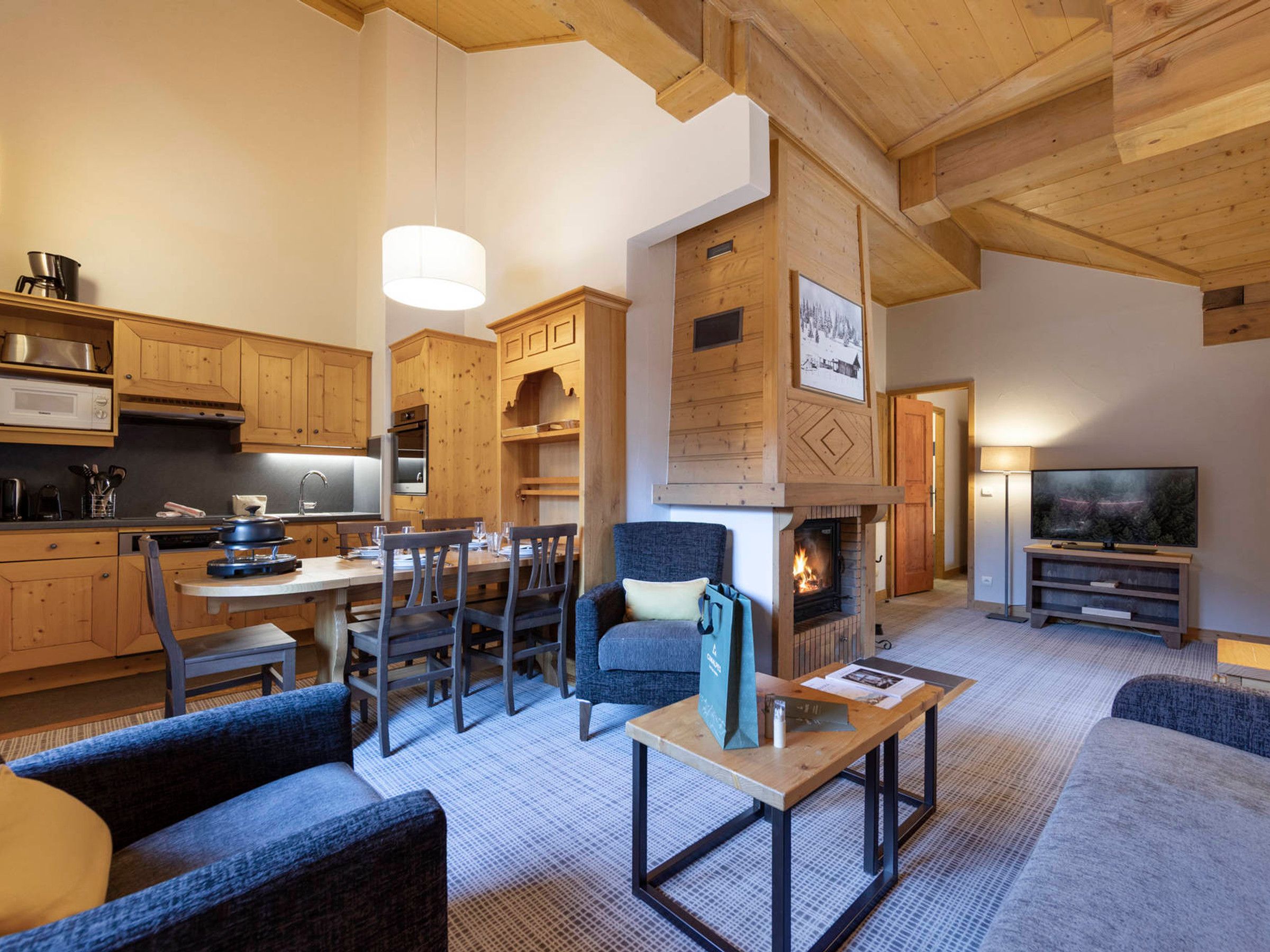 Una sala de estar moderna con chimenea, muebles de madera y televisor.
