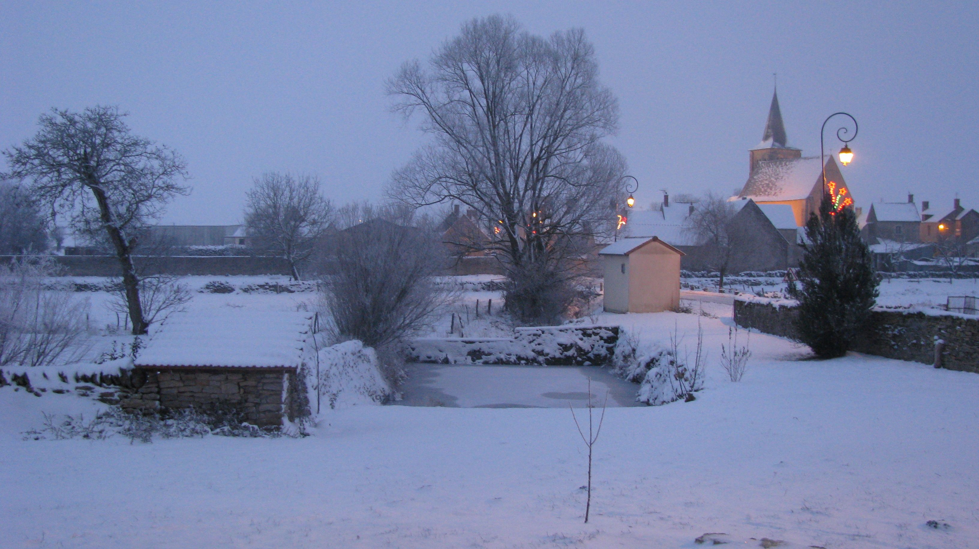Paisagem coberta de neve com uma igreja e um edifício de pedra.