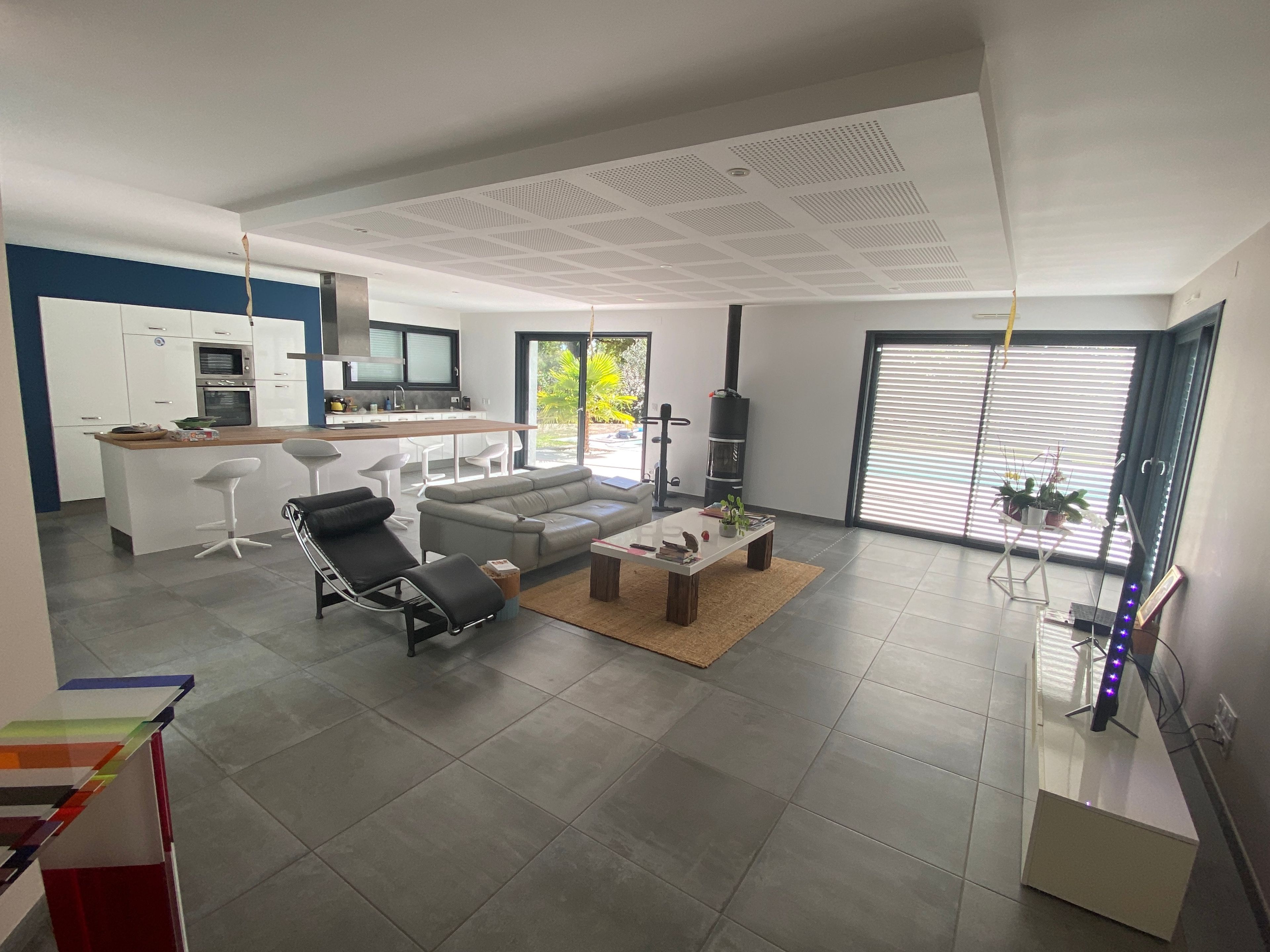 Un salon moderne avec un canapé, des fauteuils, une table basse et une cheminée.