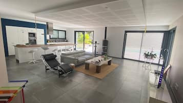 Un salon moderne avec un canapé, des fauteuils, une table basse et une cheminée.