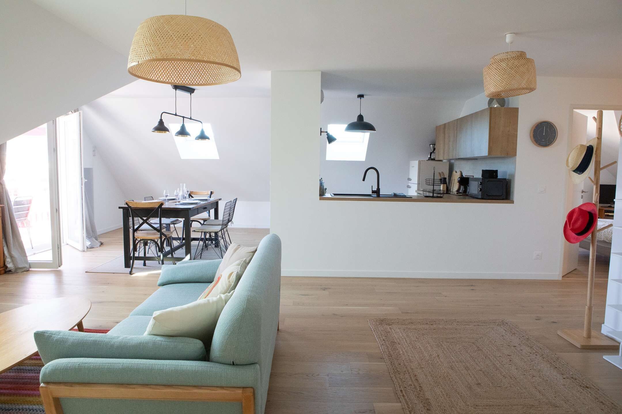 Un espace de vie moderne comprenant un canapé, une table à manger et un coin cuisine.