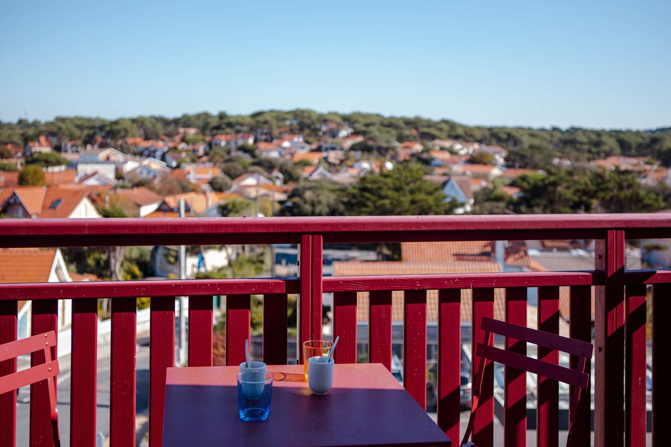 Un balcon avec une table, deux tasses et une cuillère.