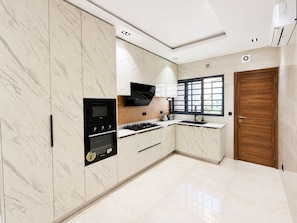 A modern kitchen with marble cabinets, a built-in oven, a gas stove, and a window with a view. - Spacious unique 3 bedroom apartment (Lagos)