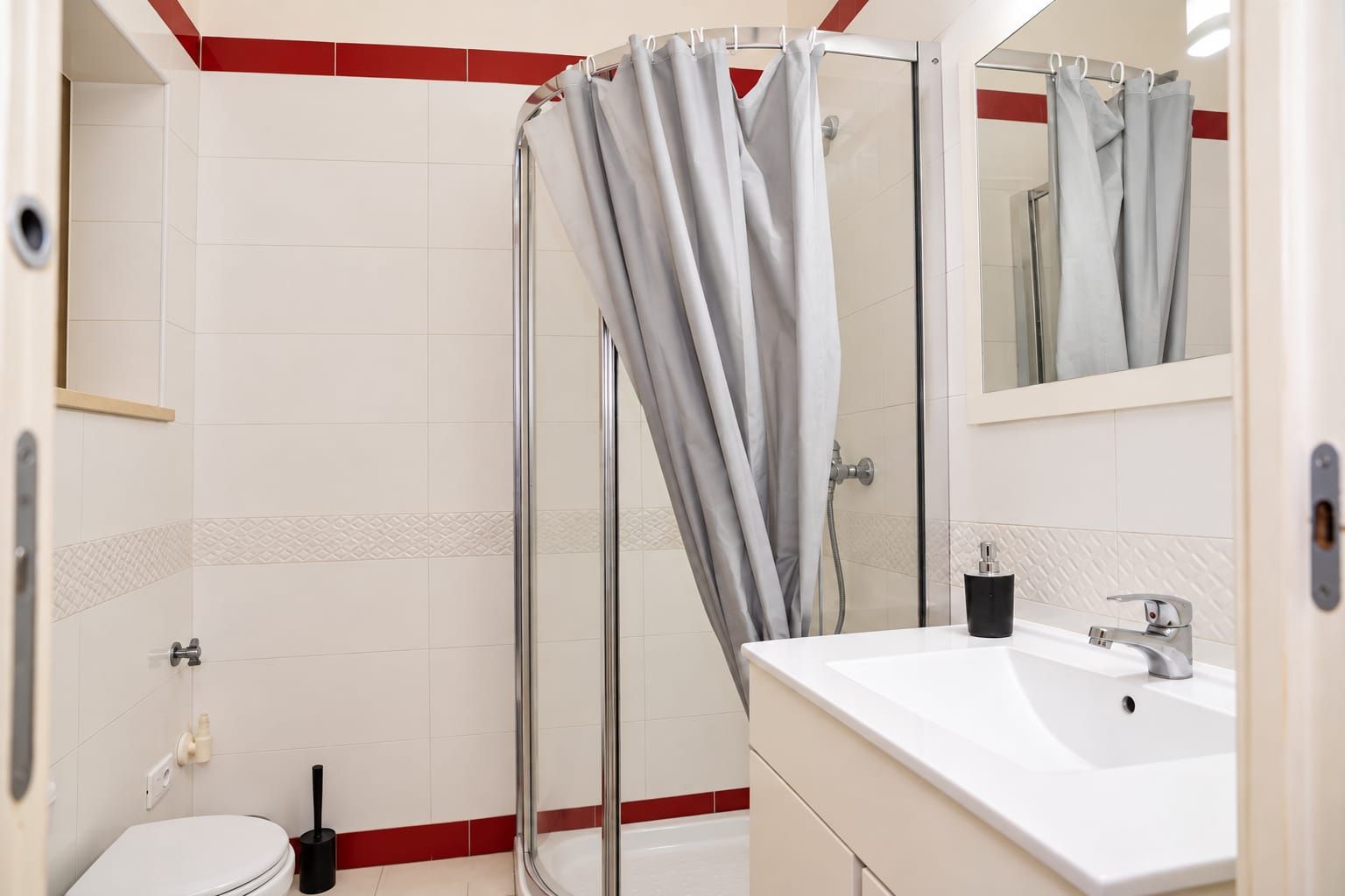 A bathroom with a shower, toilet, and sink.