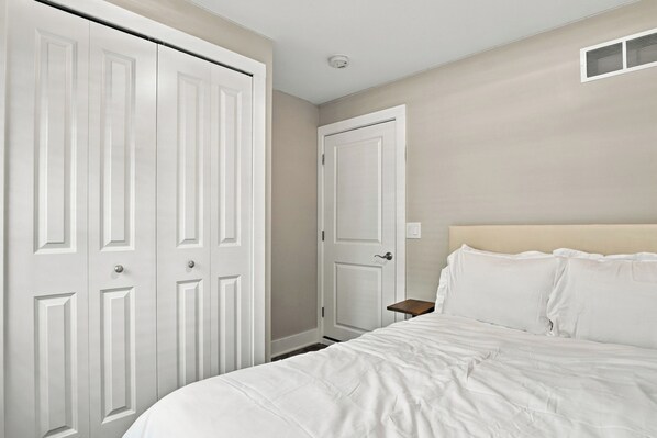 A bedroom with a bed, a nightstand, and a wardrobe.