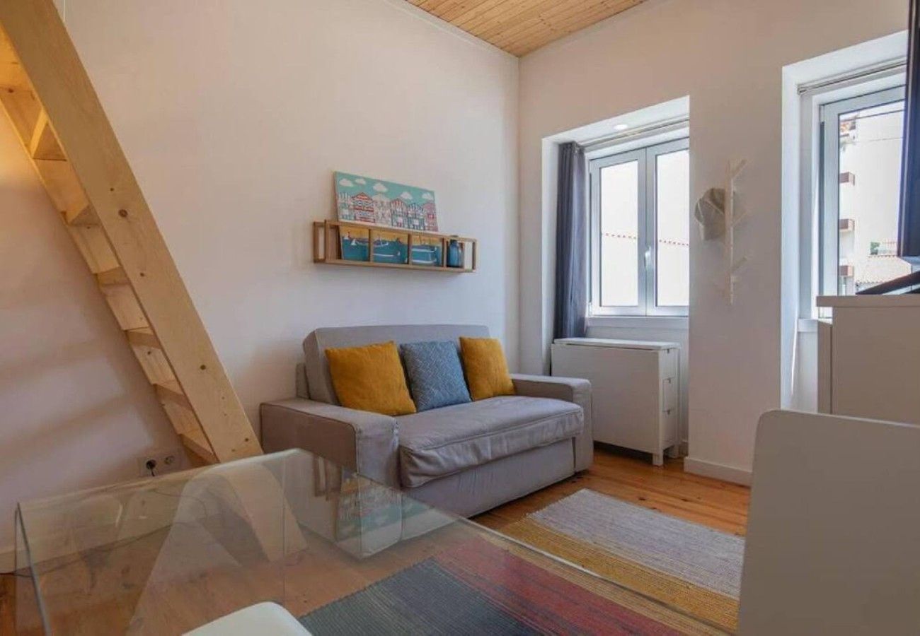 A living room with a sofa, a glass table, a window, and a radiator.