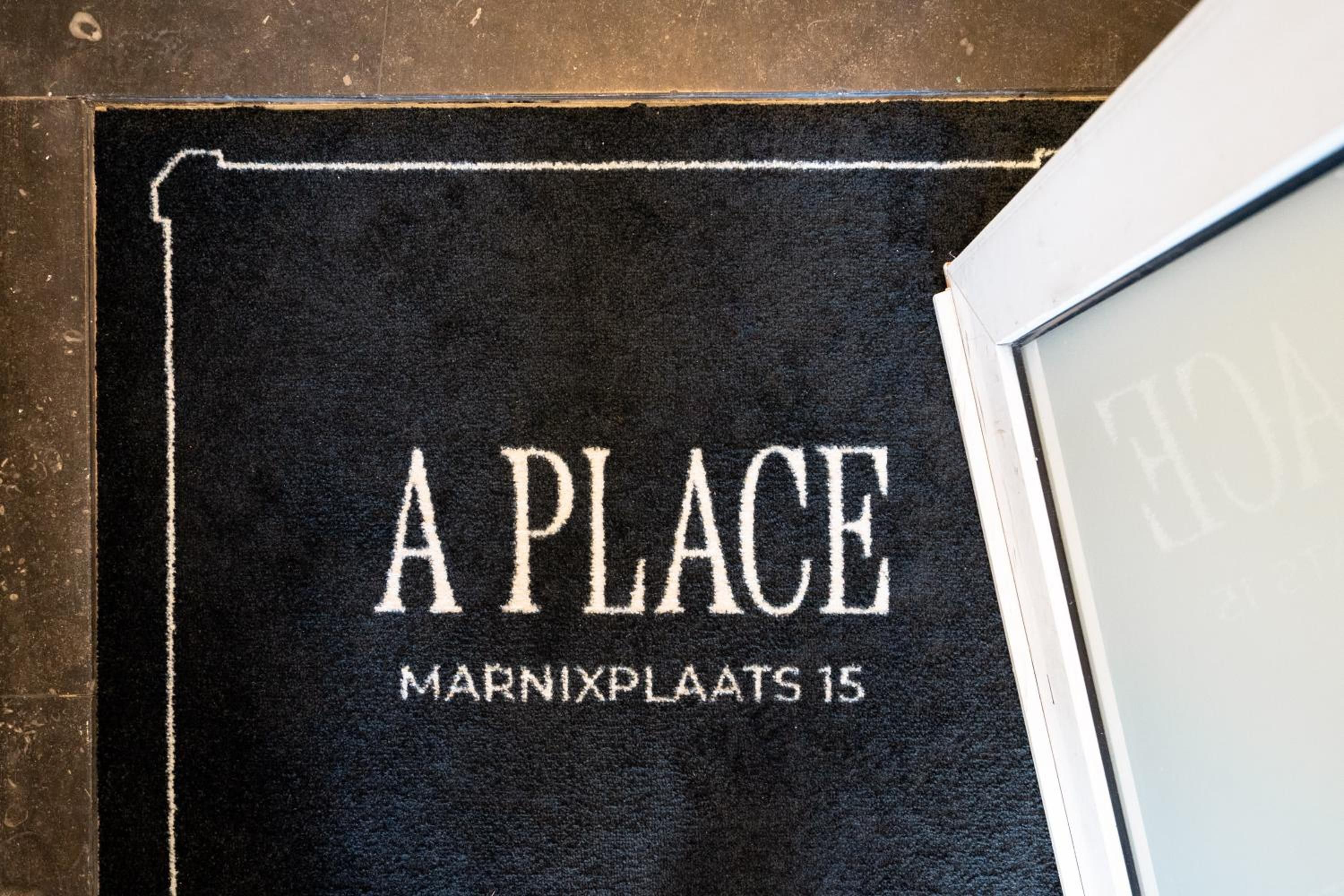 Een zwarte mat met witte letters, waarop 'A PLACE MARNIXPLAATS 15' staat.