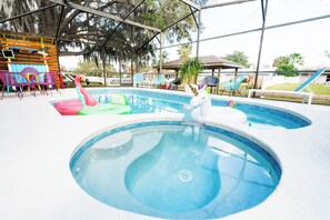 Une piscine avec des jeux gonflables et un espace détente abrité.
