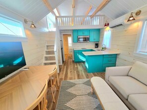 A compact living space with a kitchen, a dining area, and a seating area.