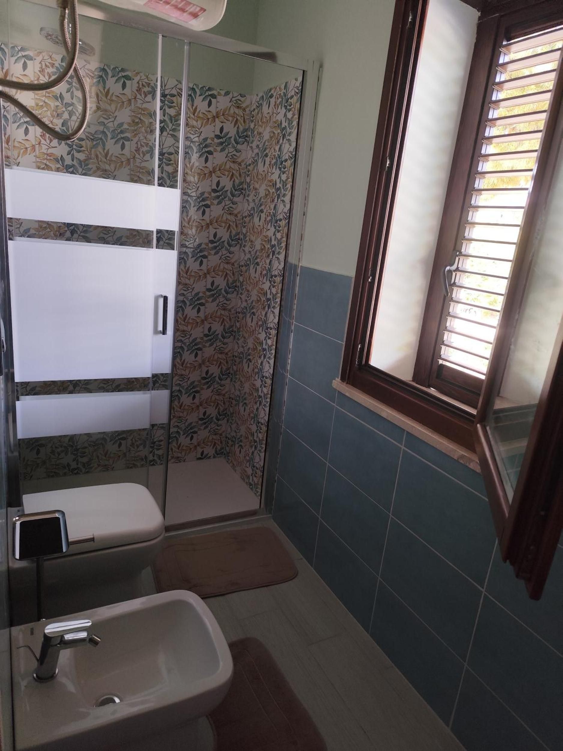 Ein Badezimmer mit Dusche, Toilette und Waschbecken.