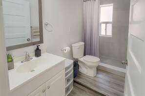 Un baño con inodoro, lavabo y ducha.