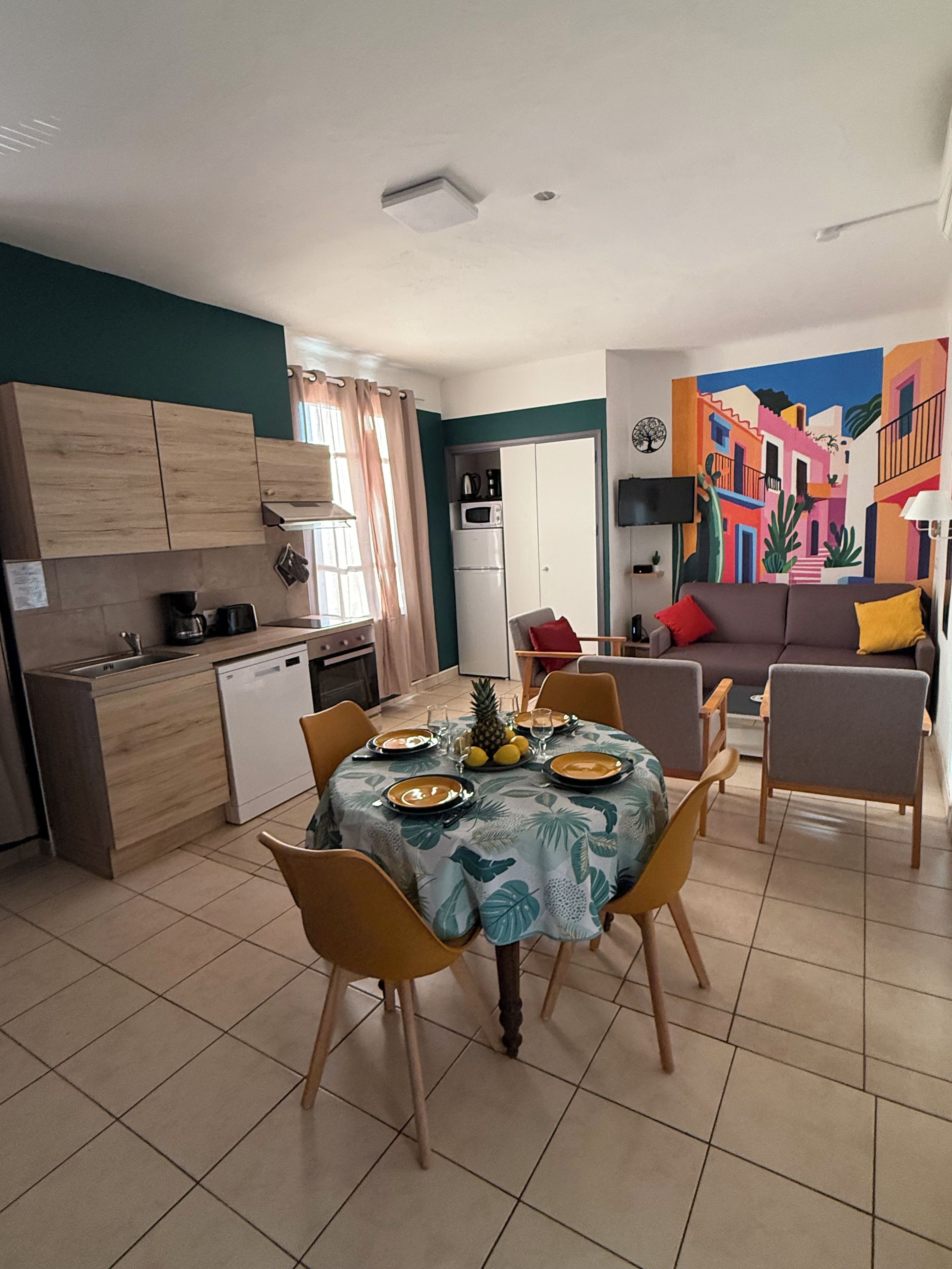 A compact living space with a dining area, kitchenette, and a sofa.