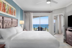 Ein Hotelzimmer mit einem großen Bett, einem Deckenventilator, einem Fernseher und einem Balkon mit Meerblick.