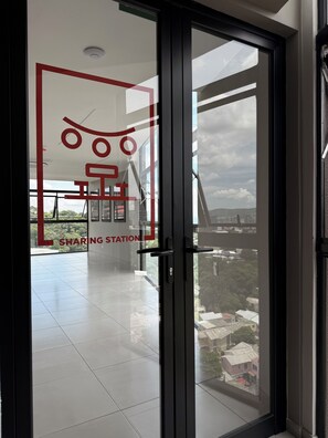 Un interior modern amb una porta de vidre que dona a un balcó amb vista a la ciutat.