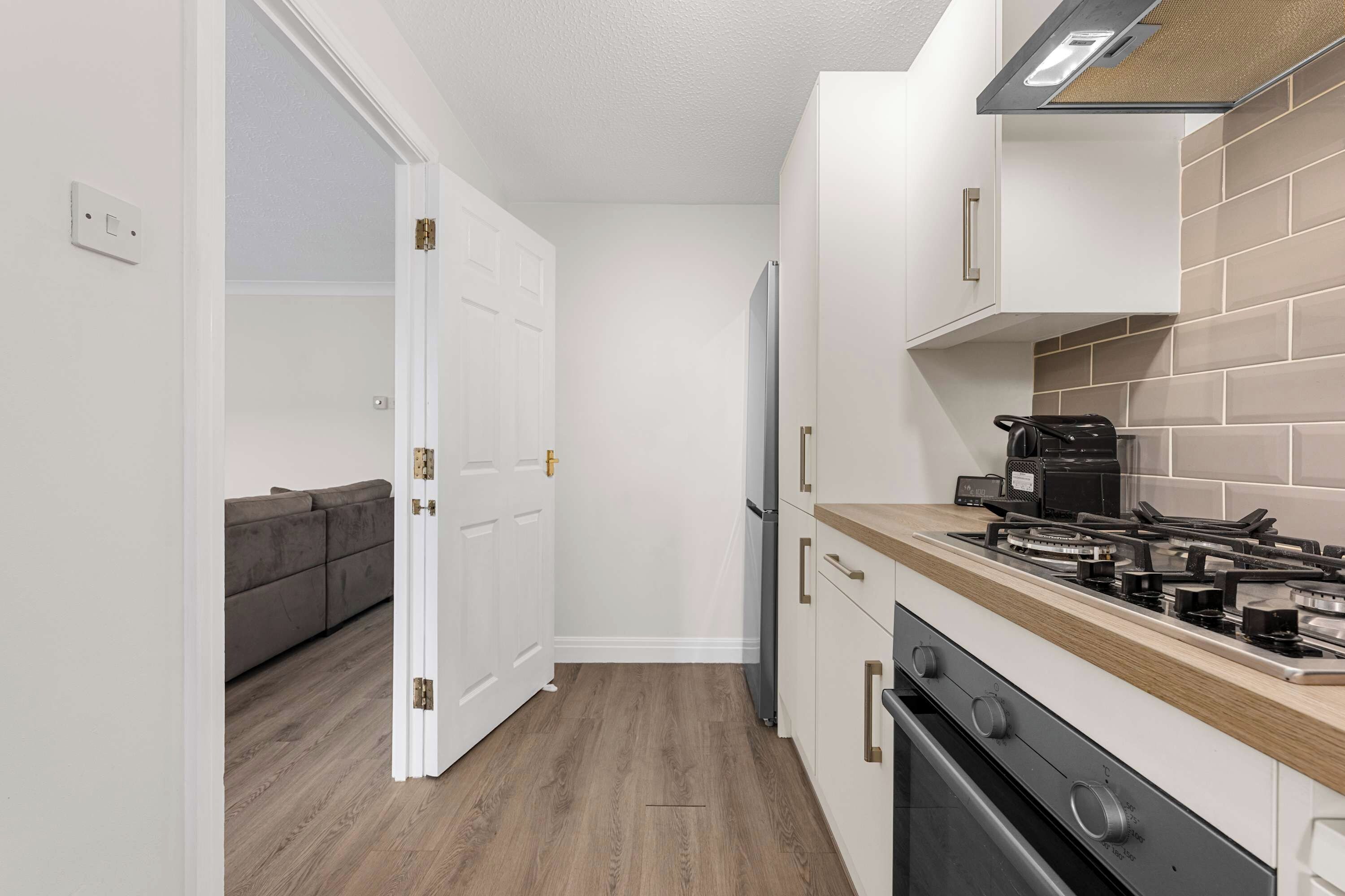Eine kleine Küche mit einem Gasherd, einem Kühlschrank und einem eingebauten Backofen.