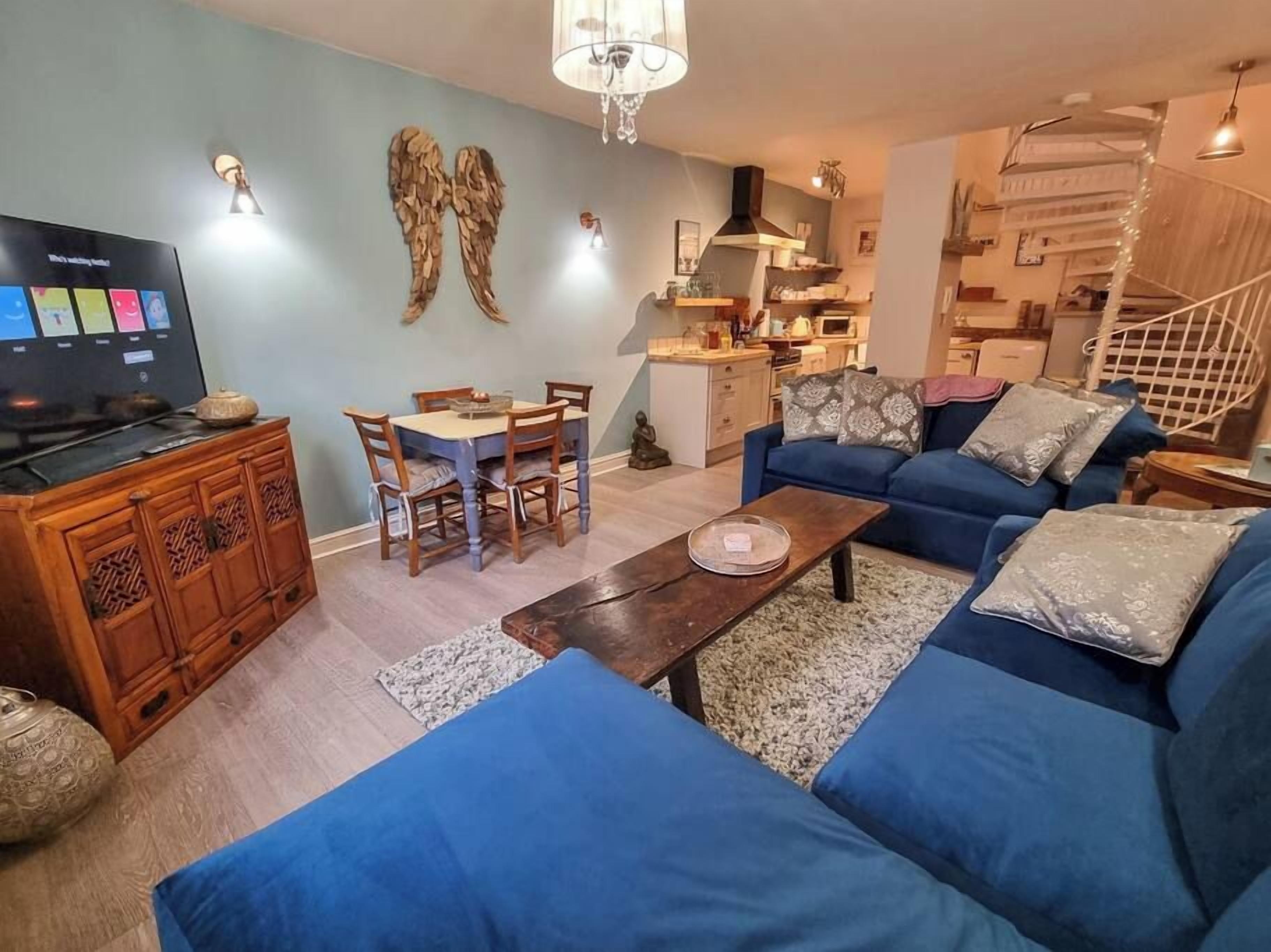 A living room with a TV, sofa, and dining area.