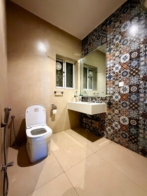 Ein Badezimmer mit Toilette, Waschbecken, Spiegel und Dusche.
