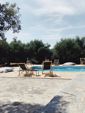 A poolside area with lounge chairs and a swimming pool.