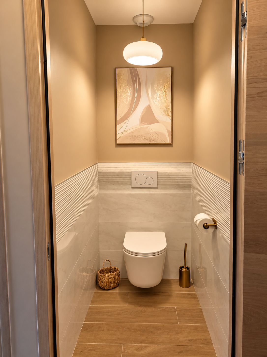 Ein modernes Badezimmer mit Toilette, Handtuchspender und einem gerahmten Kunstwerk an der Wand.