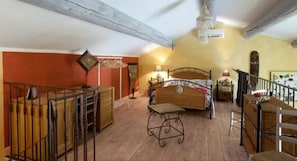 Ein Schlafzimmer mit einem Bett, Nachttischen, einer Kommode und einer Treppe.