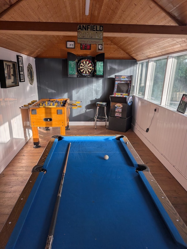 A billiards room with a pool table, foosball table, dartboard, and arcade machine. - Kirkby Home | Hot Tub, Sauna & Games Room (Merseyside)