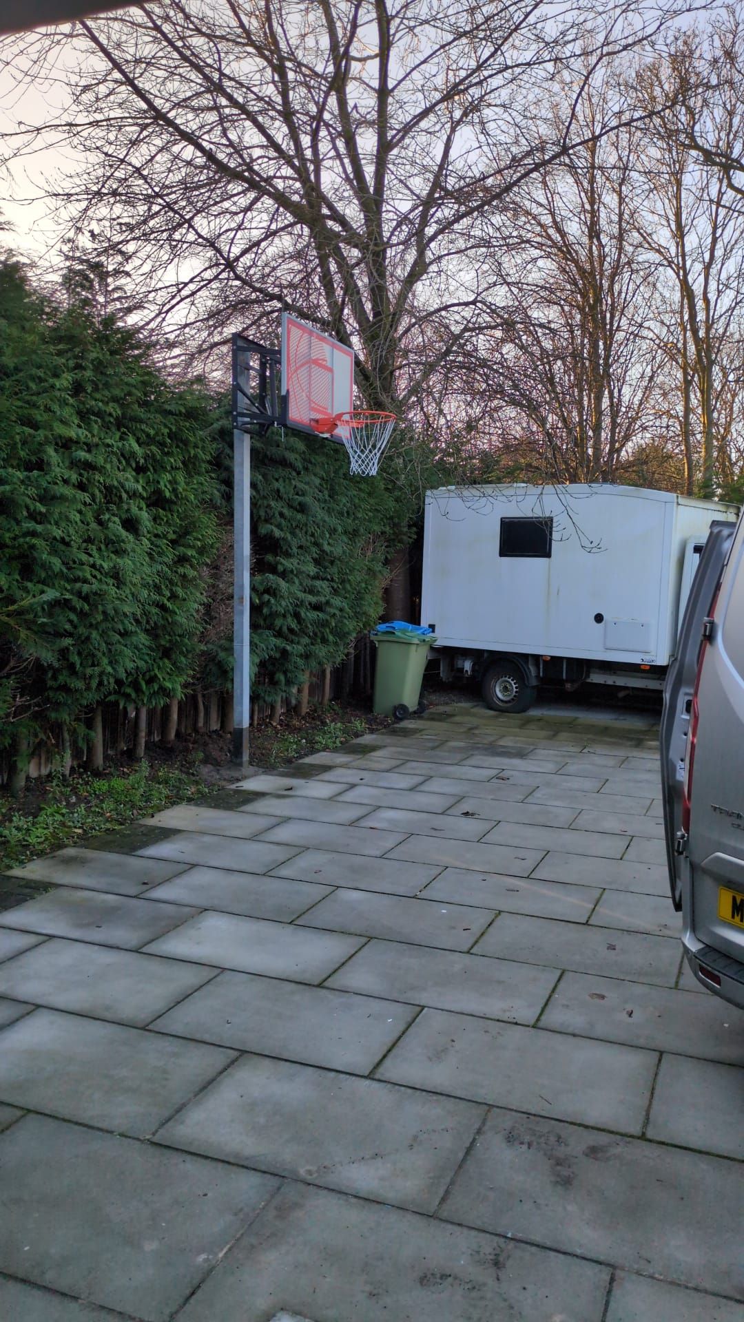 Een verharde oprit die uitkomt bij een witte vrachtwagen.