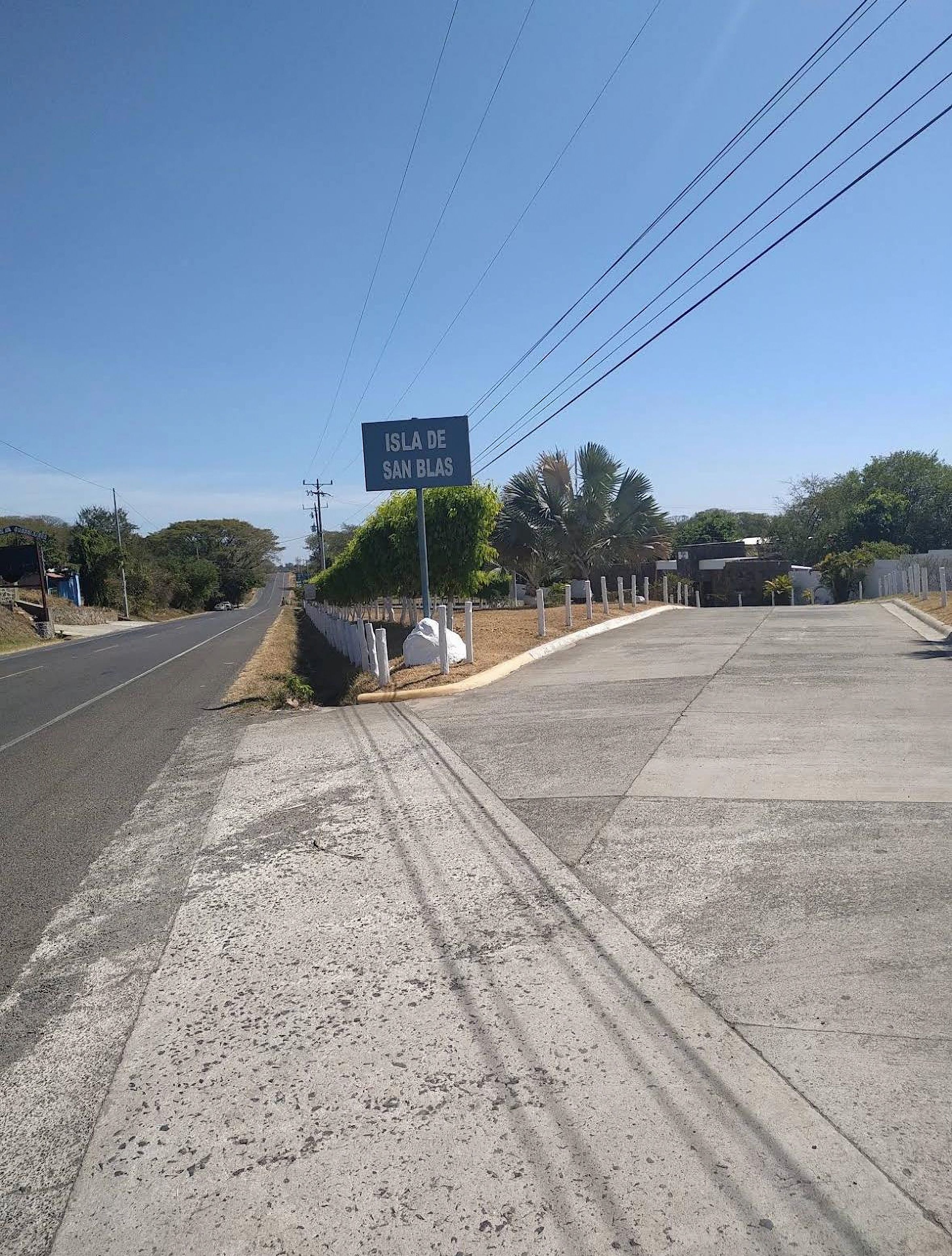 Una carretera con un cartel que dice 'Isla de San Blas' y un cielo despejado.
