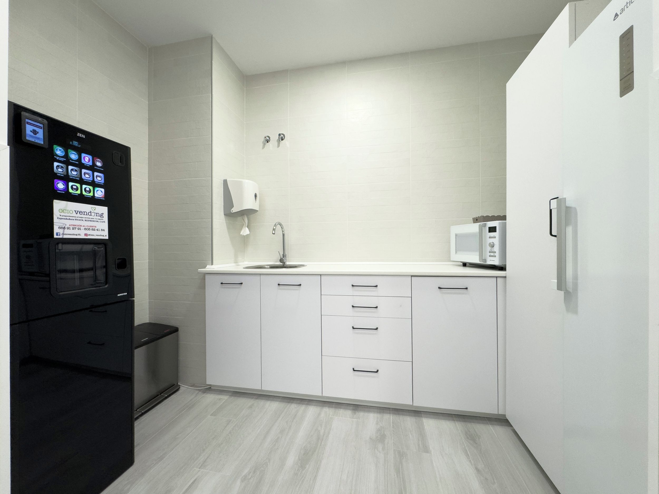 Una cocina moderna con refrigerador integrado, microondas y lavaplatos.