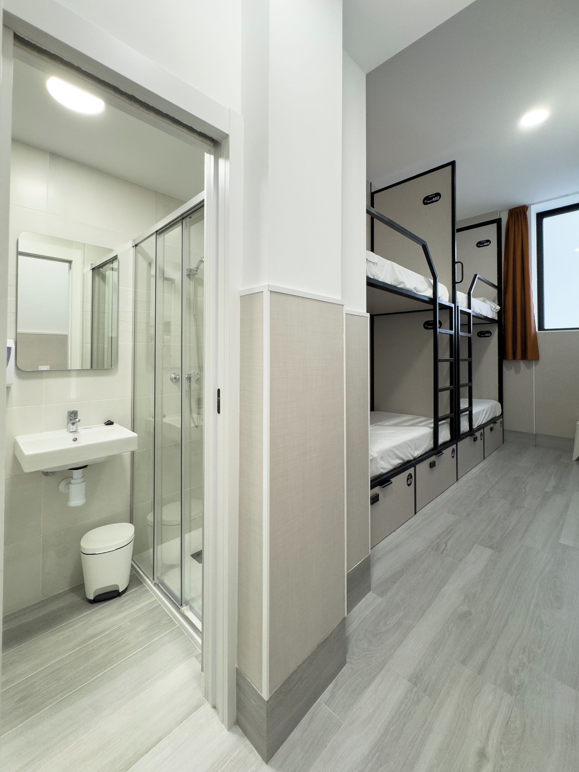 Un baño moderno con cabina de ducha de vidrio, lavamanos y inodoro.