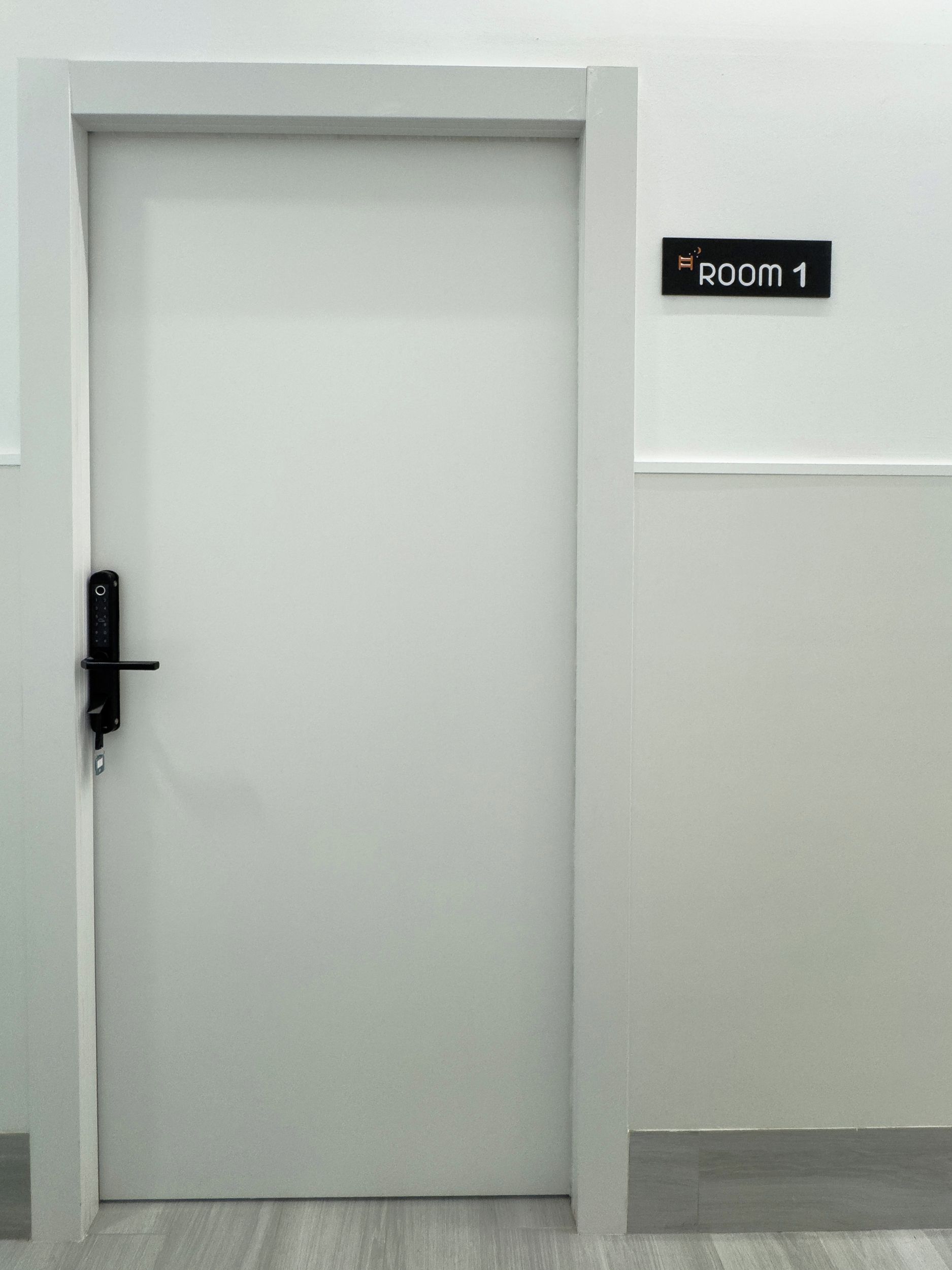A closed door with a sign above it indicating 'ROOM 1'.