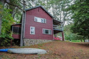 A two-story house with a stone foundation and a red exterior.